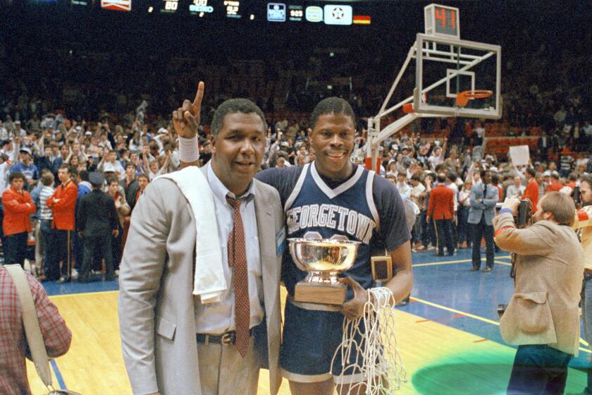 Georgetown coach John Thompson poses with player Patrick Ewing after the Hoyas won the 1985 NCAA championship game.