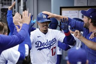 Los Angeles Dodgers' Miguel Vargas is congratulated by teammates in the dugout.