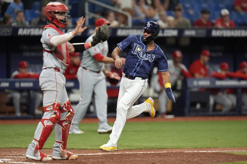 Tampa Bay Rays' Amed Rosario, right, scores next to Los Angeles Angels catcher Logan O'Hoppe on a two-run triple by Jose Caballero during the ninth inning of a baseball game Tuesday, April 16, 2024, in St. Petersburg, Fla. (AP Photo/Chris O'Meara)