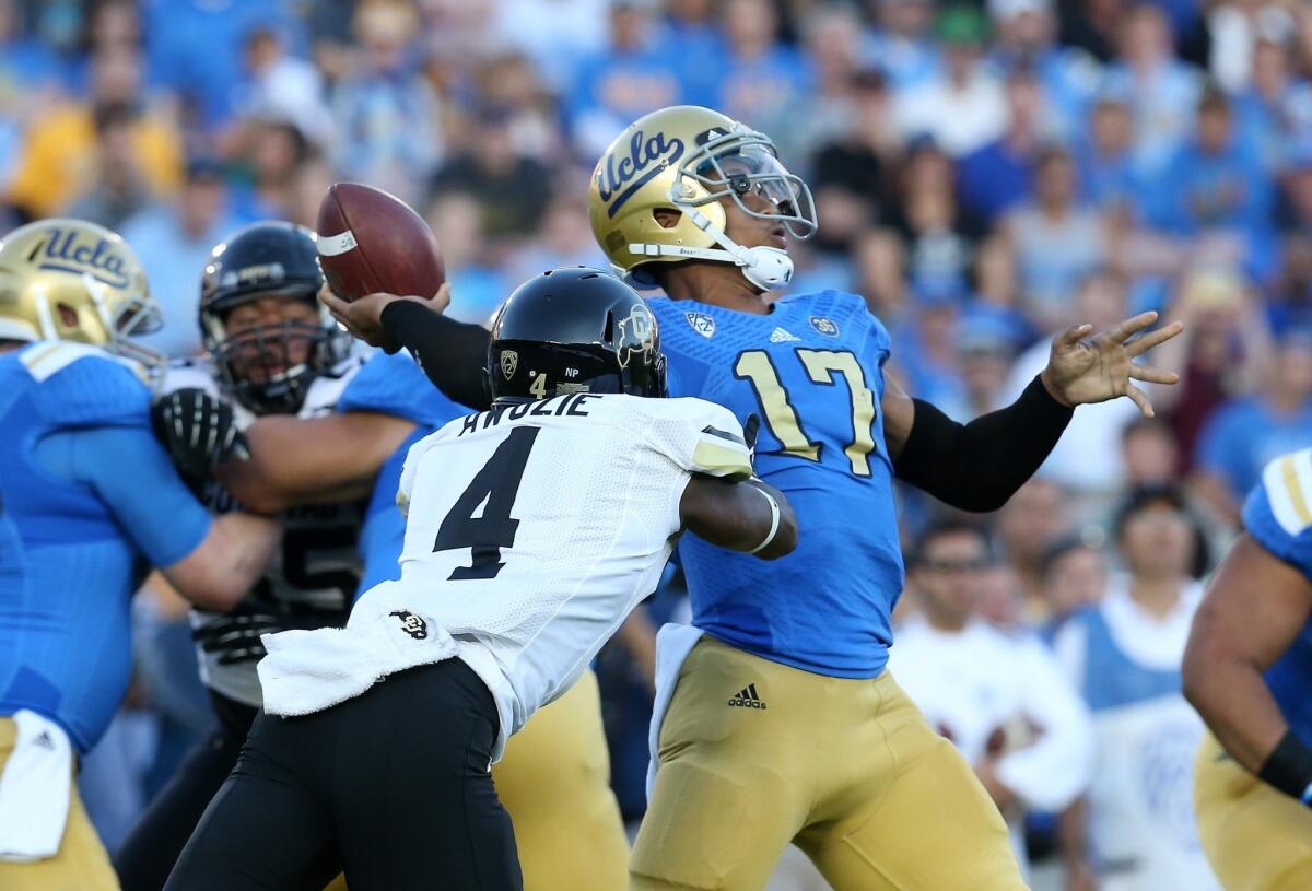 UCLA quarterback Brett Hundley fires a a touchdown pass before Colorado cornerback Chidobe Awuzie can disrupt his throw in the first quarter Saturday at the Rose Bowl.