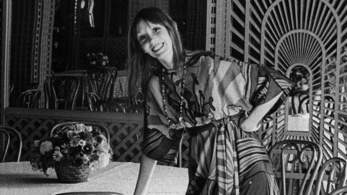 A black and white photo of actor Shelley Duvall in a patterned dress.