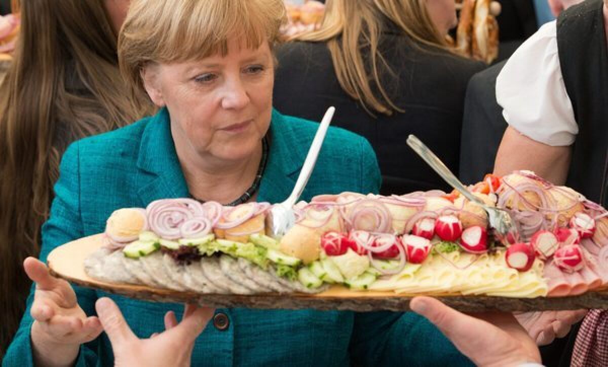 Chancellor Angela Merkel looks at a plate of sausage at a festival in Munich, Germany. Any beef on the plate might have been subject to regulations formerly expressed by the longest word in the German language.