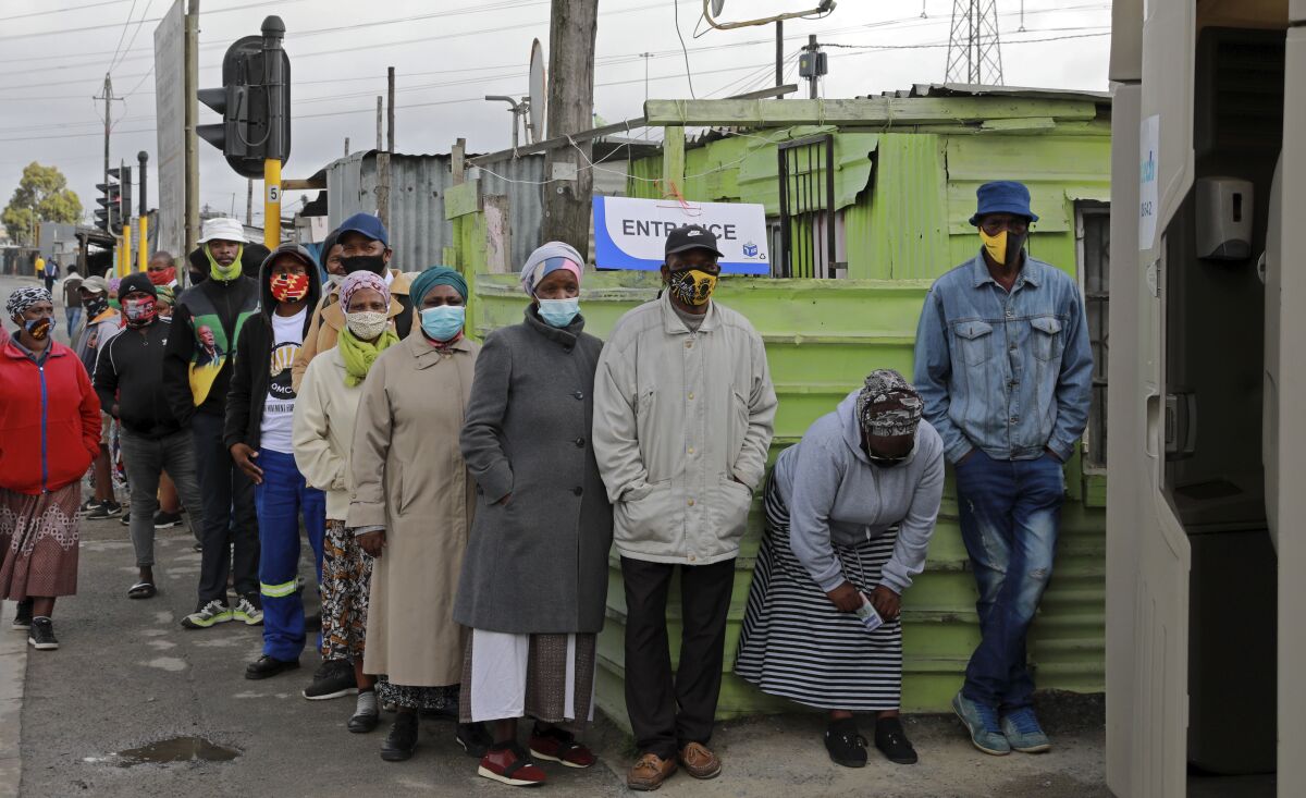 People queue outside a polling station in Khayelitsha in Cape Town, South Africa, Monday, Nov. 1, 2021. As South Africa holds crucial local elections, the country has been hit by a series of crippling power blackouts that many critics say highlight poor governance. (AP Photo/Nardus Engelbrecht)