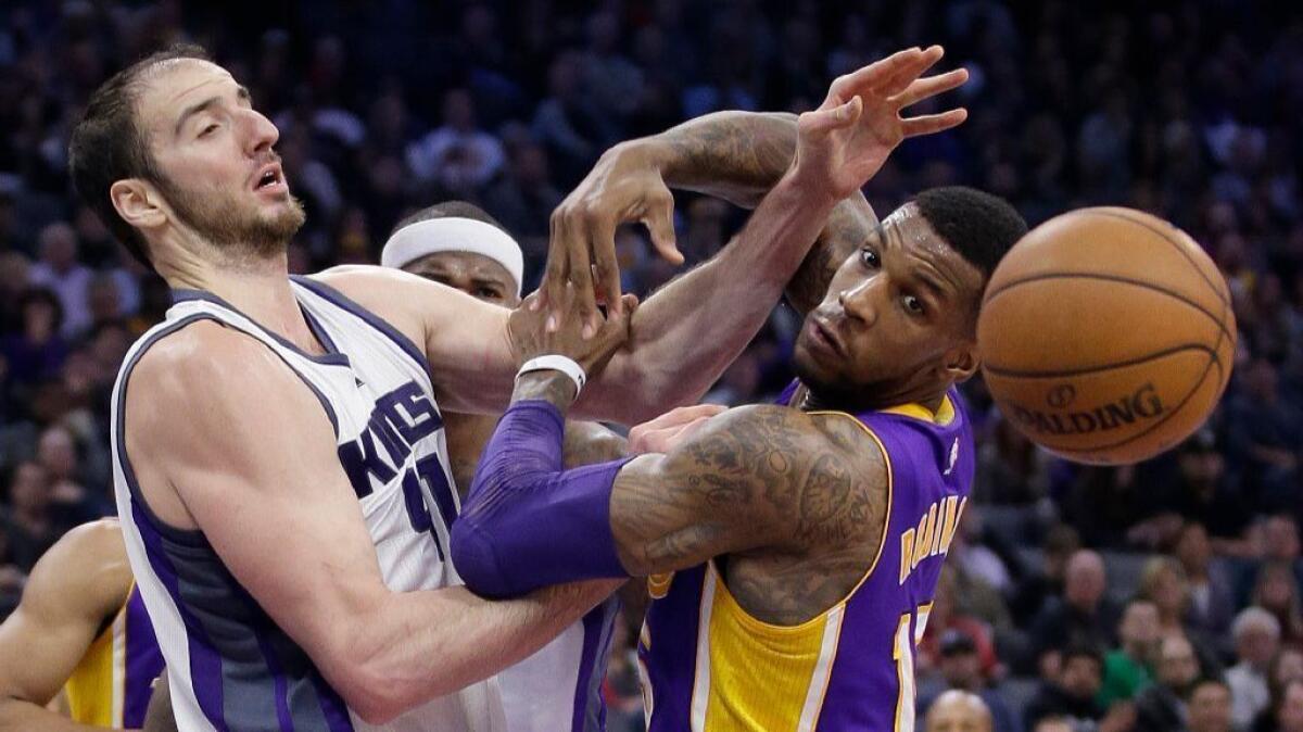 The ball gets away from Kings center Kosta Koufos and Lakers forward Thomas Robinson during the second half of a game on Dec. 12.