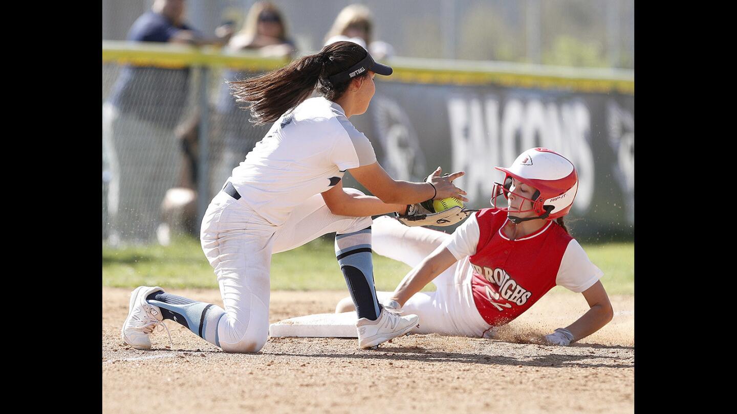 Burroughs' Hannah Skinner slides safely into third base as Crescenta Valley's Natalie Bitetti turns a little late to make the tag in a Pacific League softball game at Crescenta Valley High School on Thursday, March 28, 2018. Crescenta Valley won the game 9-0.