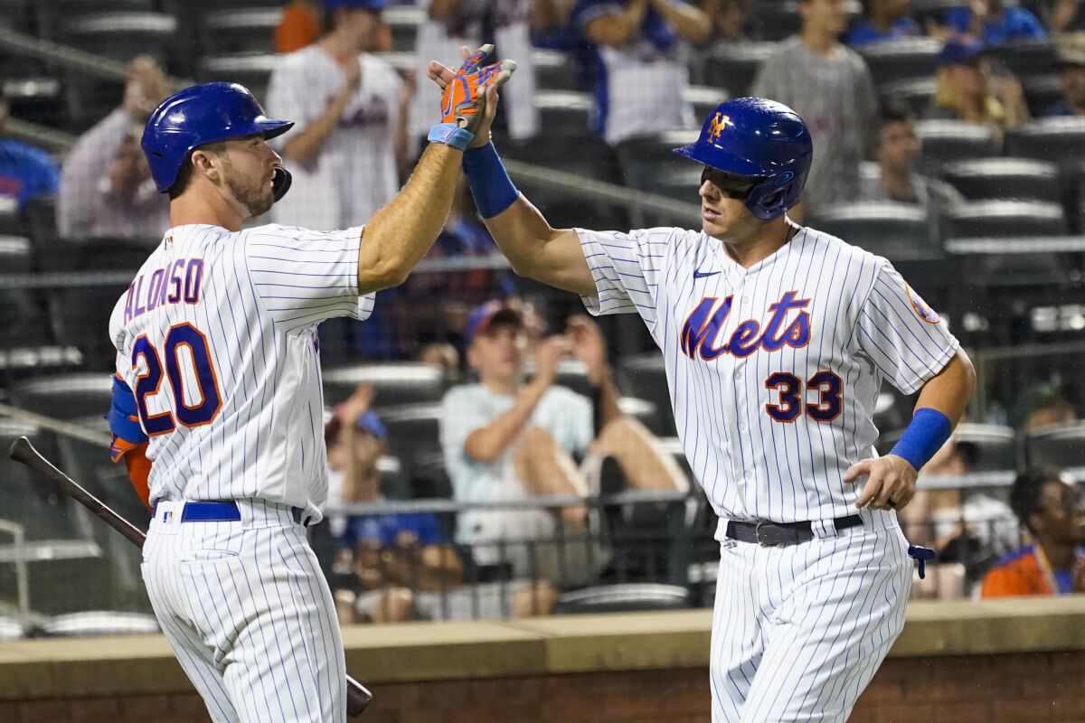 New York Mets' James McCann (33) celebrates with Pete Alonso (20) as he runs the bases to score off a base hit by Billy McKinney during the sixth inning of the second baseball game of a doubleheader against the Pittsburgh Pirates, Saturday, July 10, 2021, in New York. (AP Photo/Mary Altaffer)