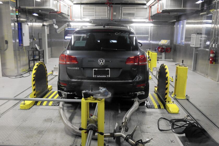 Volkswagen denied installing software in six-cylinder diesel vehicles that changes engine performance during emissions testing. Above, a VW Touareg diesel is tested last month at an EPA facility in Michigan.