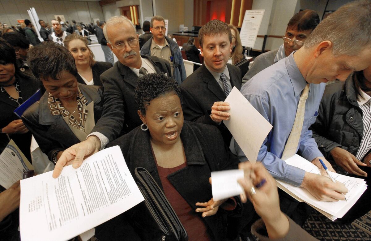 Job seekers hand over resumes while trying to get information at a job fair in Livonia, Mich., in 2009. The U.S. economy has made strides since recovery began in June of that year, but many are still experiencing growing pains.
