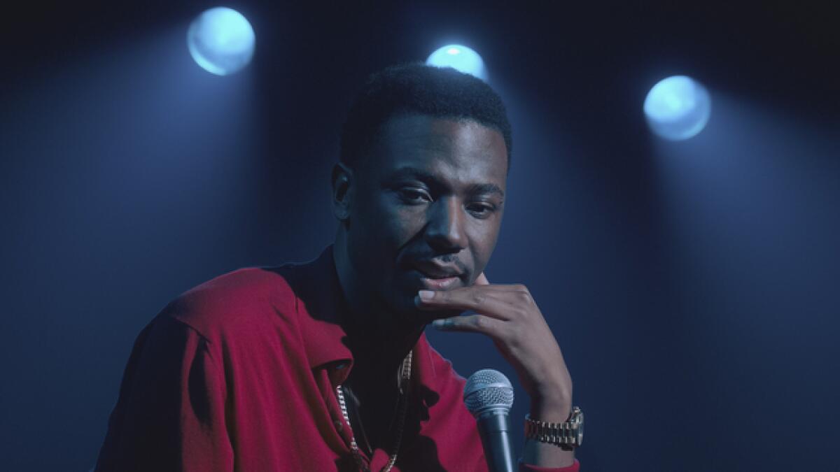 A man in a red shirt looking pensive