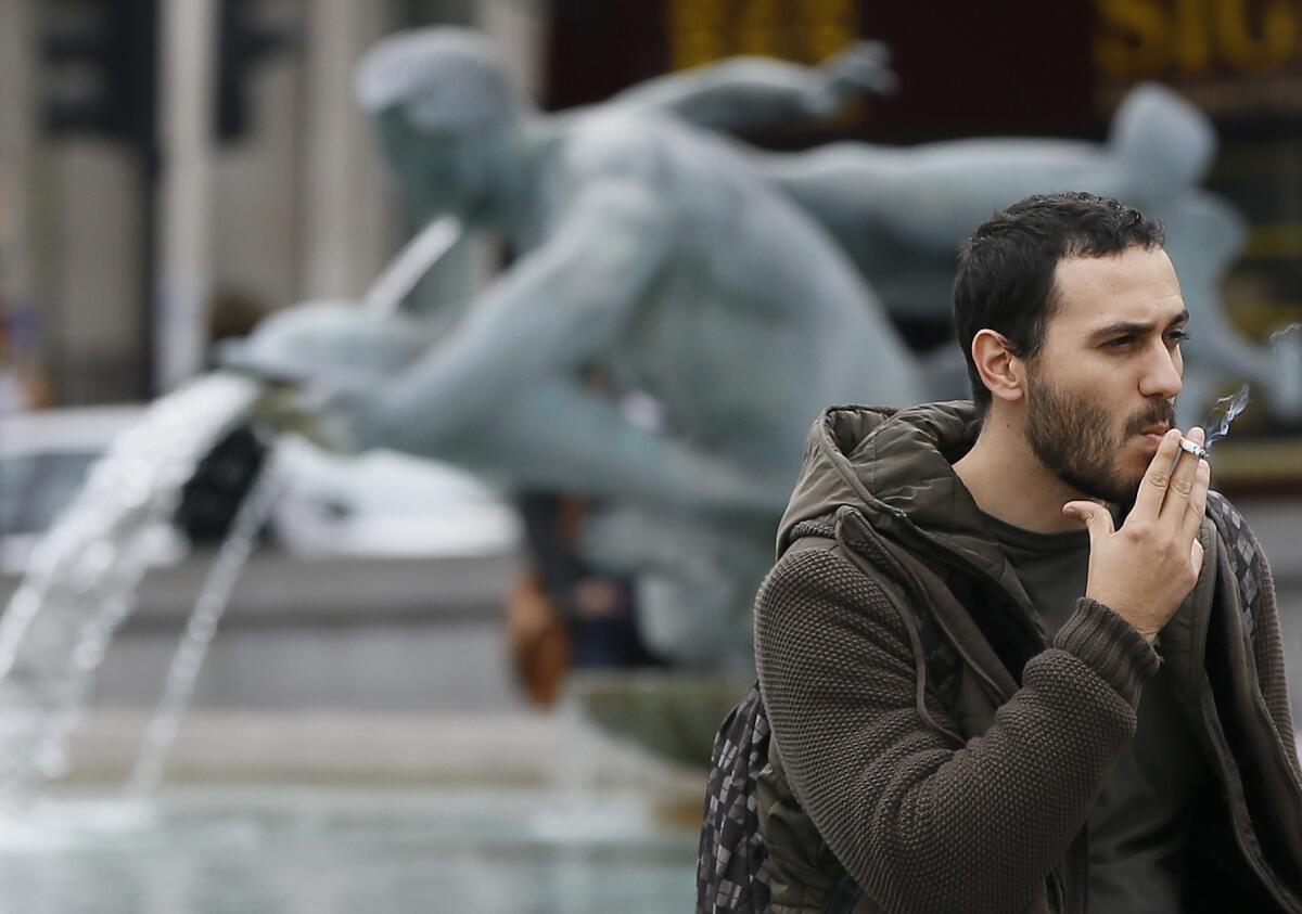 Man smoking by a fountain in Trafalgar Square in London