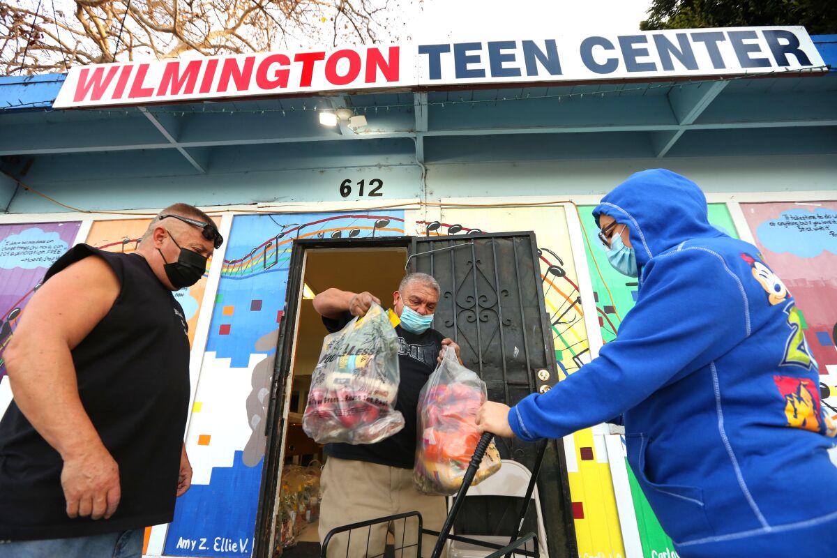 A woman receives bags of food at the Wilmington Teen Center 