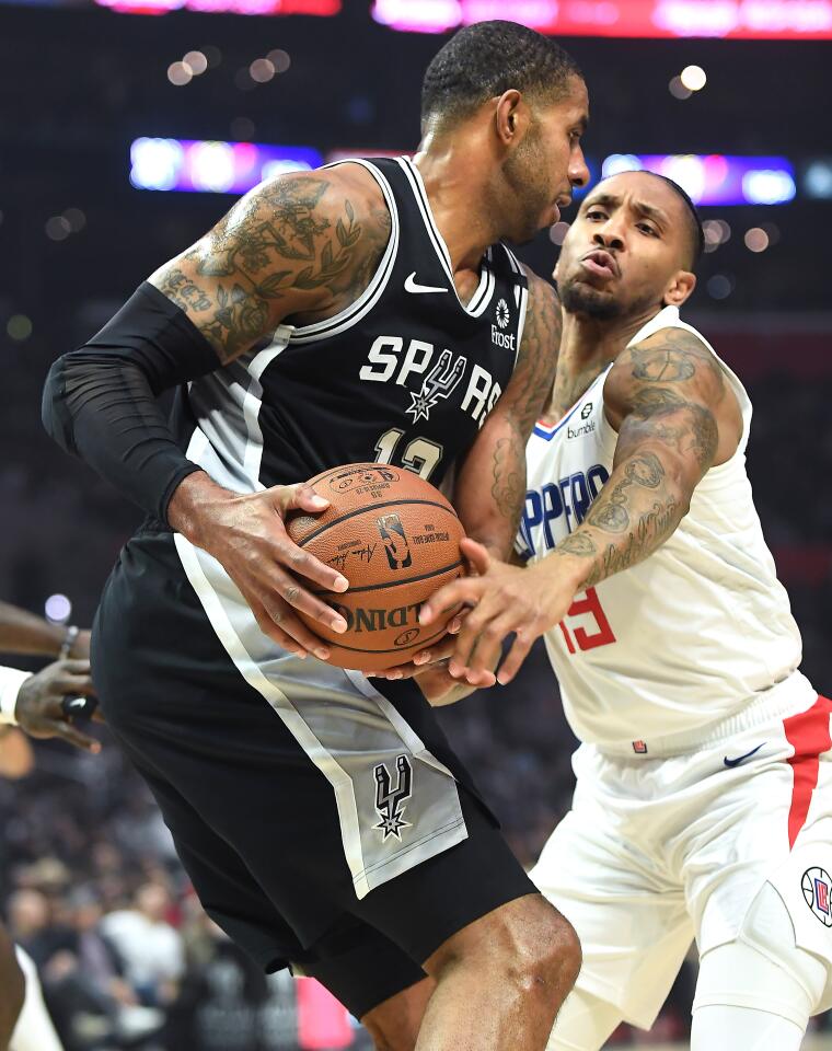Clippers guard Rodney McGruder, right, tries to steal the ball away from Spurs forward LaMarcus Aldridge during the first quarter.