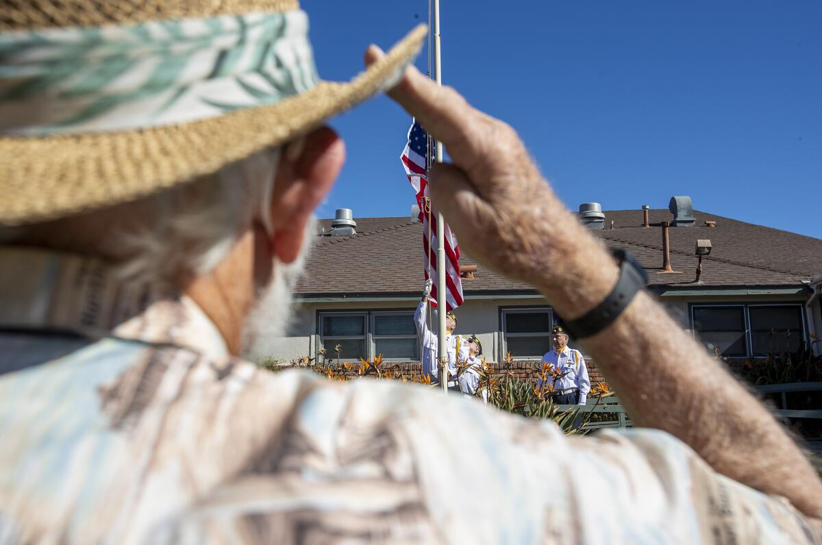 Bob Dettloff salutes as the U.S. flag lowers for the last time at the Rodgers Seniors' Center on Friday.