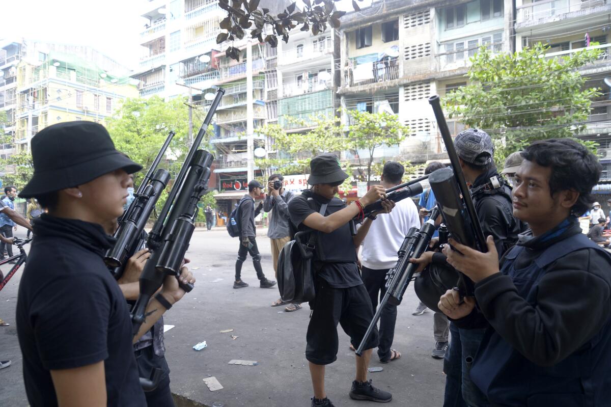 Anti-coup protesters armed with homemade air rifles join a protest in Yangon, Myanmar.