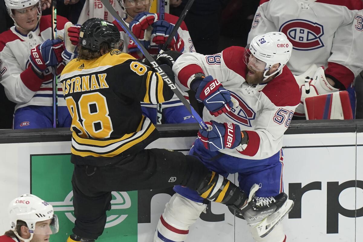 Boston Bruins right wing David Pastrnak (88) and Montreal Canadiens defenseman David Savard (58) collide during the first period of an NHL hockey game, Thursday, March 23, 2023, in Boston. (AP Photo/Steven Senne)