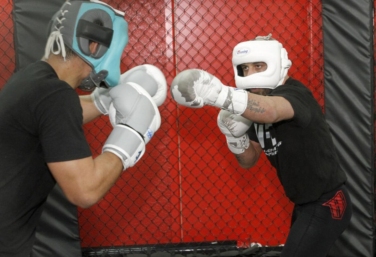Manny Gamburyan, right, trains for his upcoming fight with sparring partner Alfred Khashakyan, left, at the Glendale Fighting Club in Glendale on Thursday, Dec. 19, 2013.