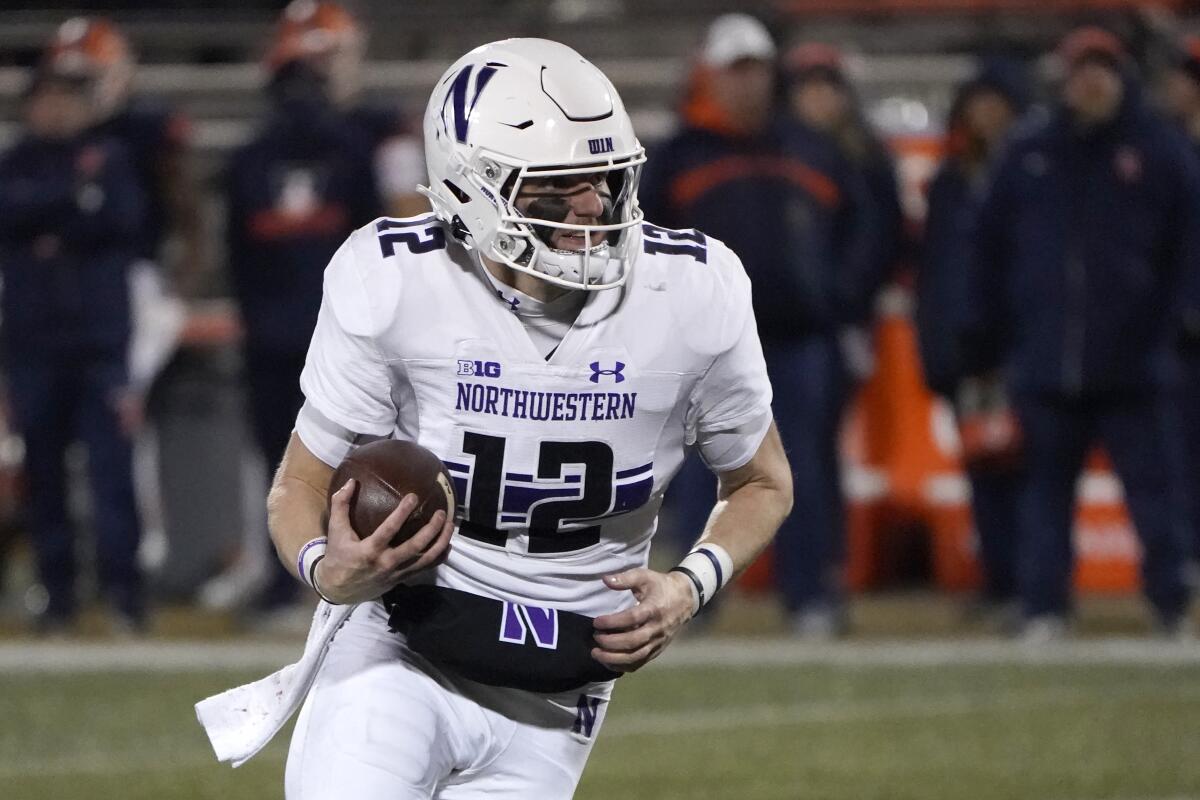 FILE - Northwestern quarterback Ryan Hilinski carries the ball during the second half of an NCAA college football game against Illinois Saturday, Nov. 27, 2021, in Champaign, Ill. Northwestern is set to kick off its season on Aug. 27, 2022, against Nebraska. (AP Photo/Charles Rex Arbogast, File)