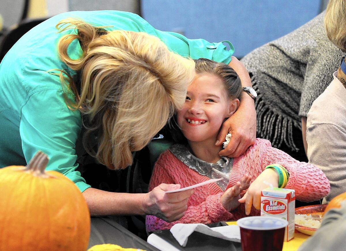 Meadow Park Elementary Emma Ford, right, gives a card to instructional aide Dawn Mallek and gets a well deserved hug for her efforts during the school's Thanksgiving meal event.
