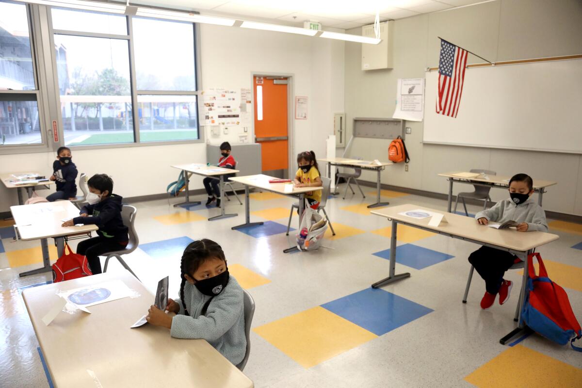 First-grade students attend class while sitting socially distanced and wearing masks