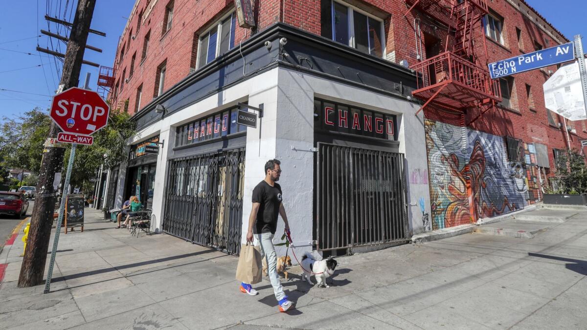 A man walks by now-closed-for-business coffeehouse Change in the Echo Park neighborhood of Los Angeles on May 4.