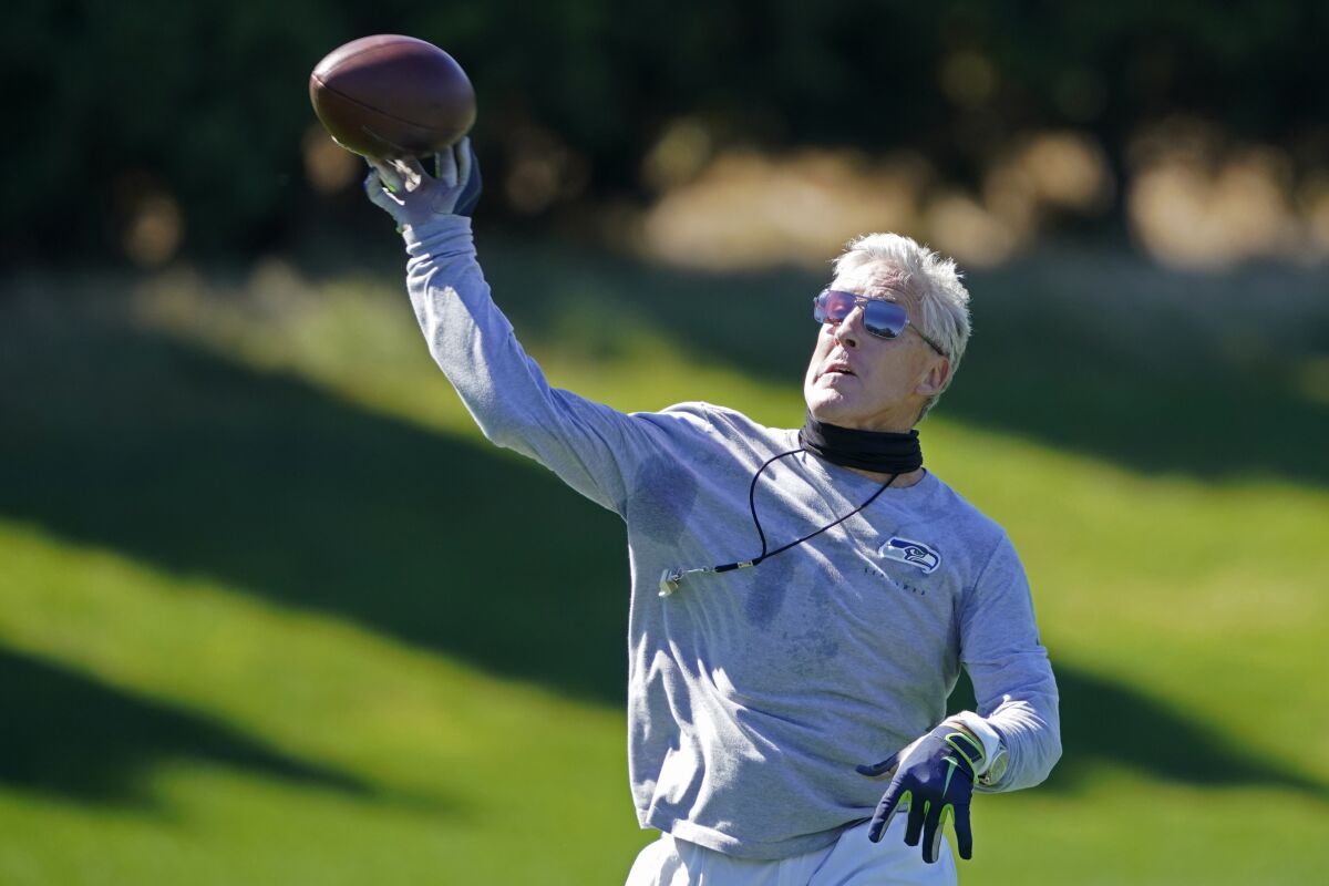 Seattle Seahawks head coach Pete Carroll passes the football during NFL football training camp, Thursday, Sept. 3, 2020, in Renton, Wash. (AP Photo/Ted S. Warren)