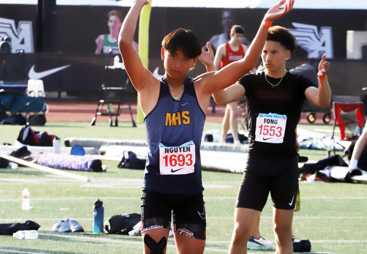 Marina's Khang Nguyen engages the crowd before a triple jump attempt in the Arcadia Invitational on Saturday.