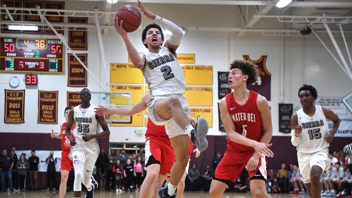 Scotty Pippen Jr. of Chatsworth Sierra Canyon drives to the basket against Devin Askew of Santa Ana Mater Dei in the third quarter of the Southern California Regional Open Division title game Tuesday at Simi Valley High.