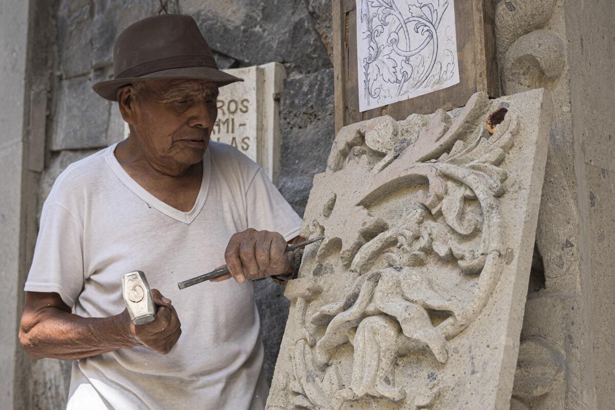 El maestro cantero Tomás Ugarte esculpe una losa en el municipio de Ciudad de México