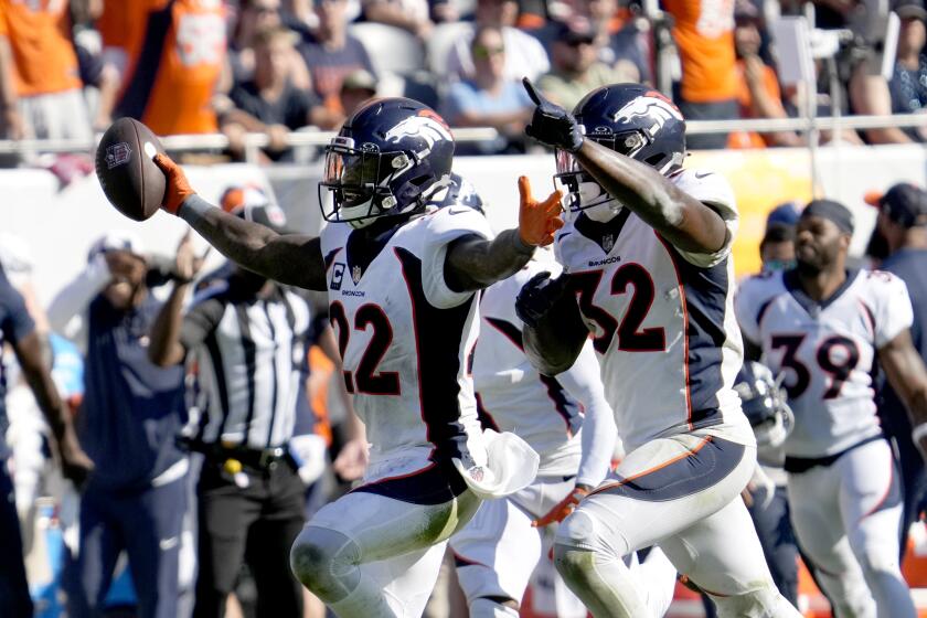 Denver Broncos safety Kareem Jackson (22) celebrates with safety Delarrin Turner-Yell (32) after his game winning interception of a pass by Chicago Bears quarterback Justin Fields during the second half of an NFL football game Sunday, Oct. 1, 2023, in Chicago. The Broncos won 31-28. (AP Photo/Nam Y. Huh)