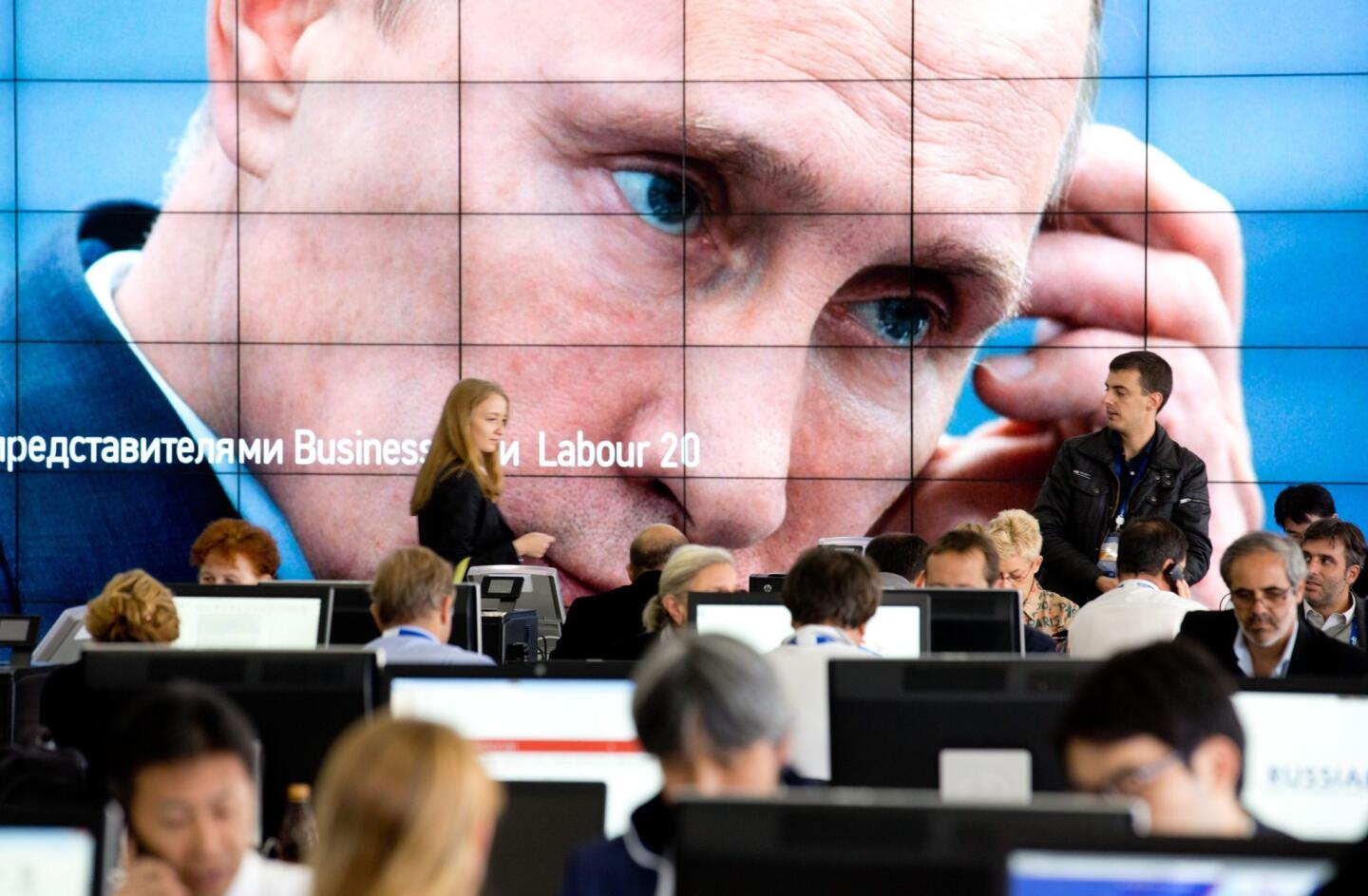 The eyes of Russia's President Vladimir Putin peer out from a giant screen in the media center at the G20 summit in St. Petersburg.