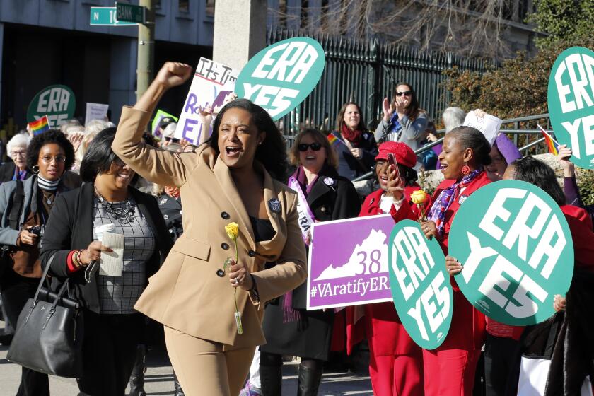 Delegate Jennifer Carroll Foy, D-Price William, cheers on Equal Rights Amendment demonstrators outside the Capitol in Richmond, Va., Wednesday, Jan. 9, 2019. The 2019 session of the General Assembly opens today. (AP Photo/Steve Helber)