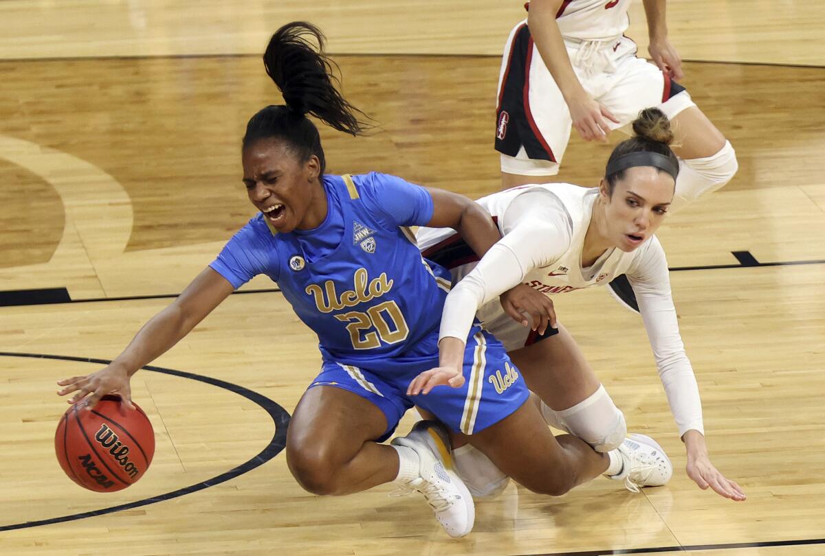 Stanford guard Lacie Hull and UCLA guard Charisma Osborne reach for the ball.