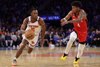 El base de los Knicks de Nueva York Immanuel Quickley avanza hacia la canasta superando al base de los Rockets de Houston Jalen Green en el encuentro del lunes 27 de marzo del 2023. (AP Foto/Adam Hunger)