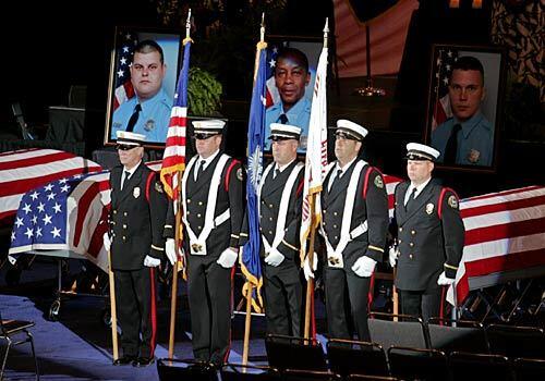 An honor guard stands in front of the row of nine caskets.