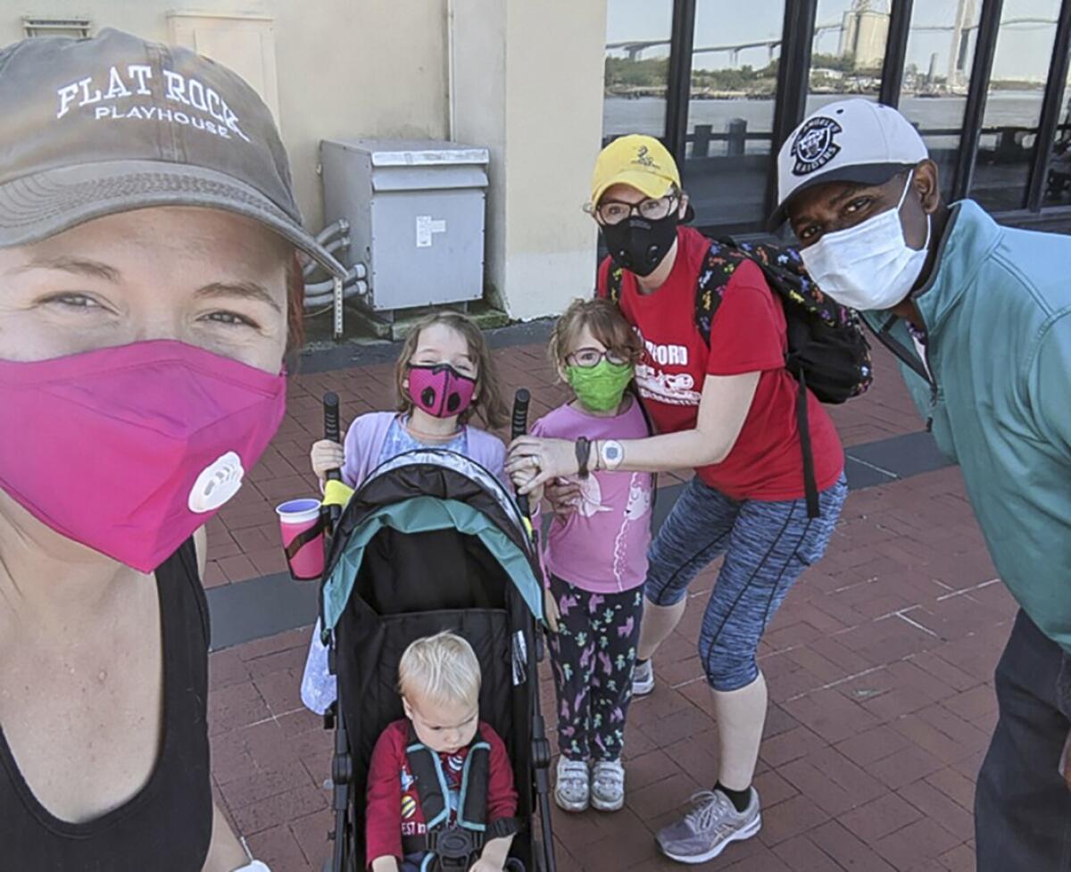 Amir Jamal Touré, right, with Elizabeth Brendel Horn , left, and her family during a Day Clean Journeys walking tour.