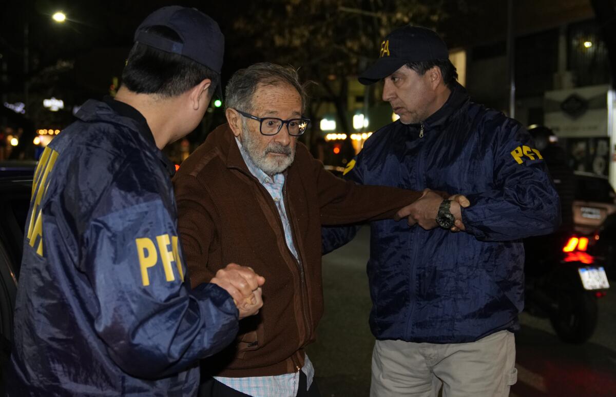 FILE - Police escort Juan Percowicz to serve pre-trial detention at his home in Buenos Aires, Argentina, Aug. 30, 2022. Authorities have identified Percowicz, 84, as the leader of the sect-like Buenos Aires Yoga School, which did not offer yoga classes and is under investigation for alleged sex trafficking, money laundering, extortion and other crimes. (AP Photo/Natacha Pisarenko, File)