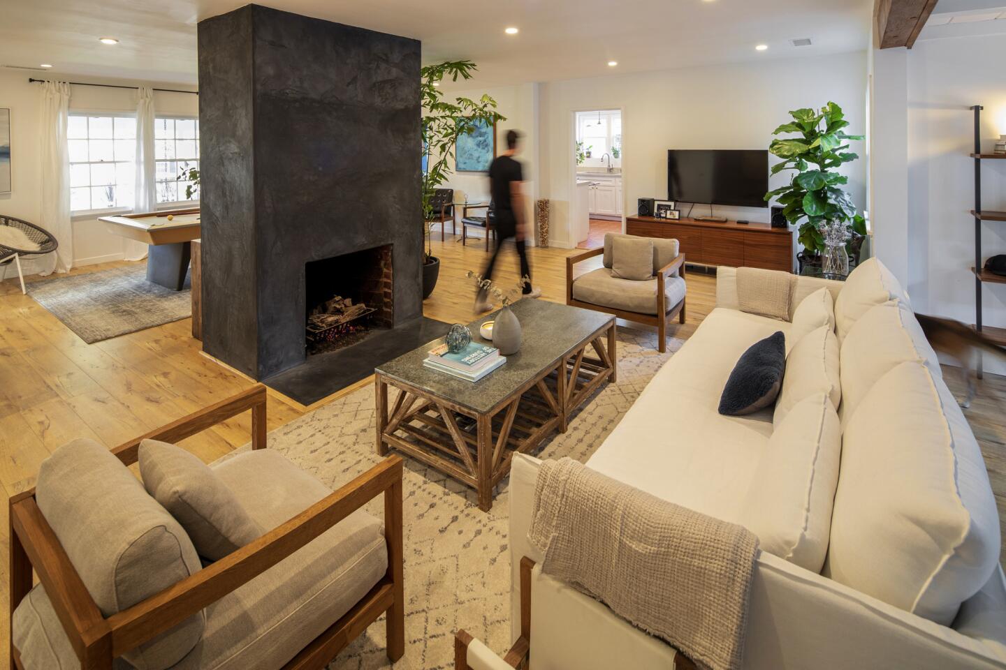 To give the interiors a more modern feel, Leiaghat removed the wall between the living room and den and covered the existing red brick fireplace with gray stucco.