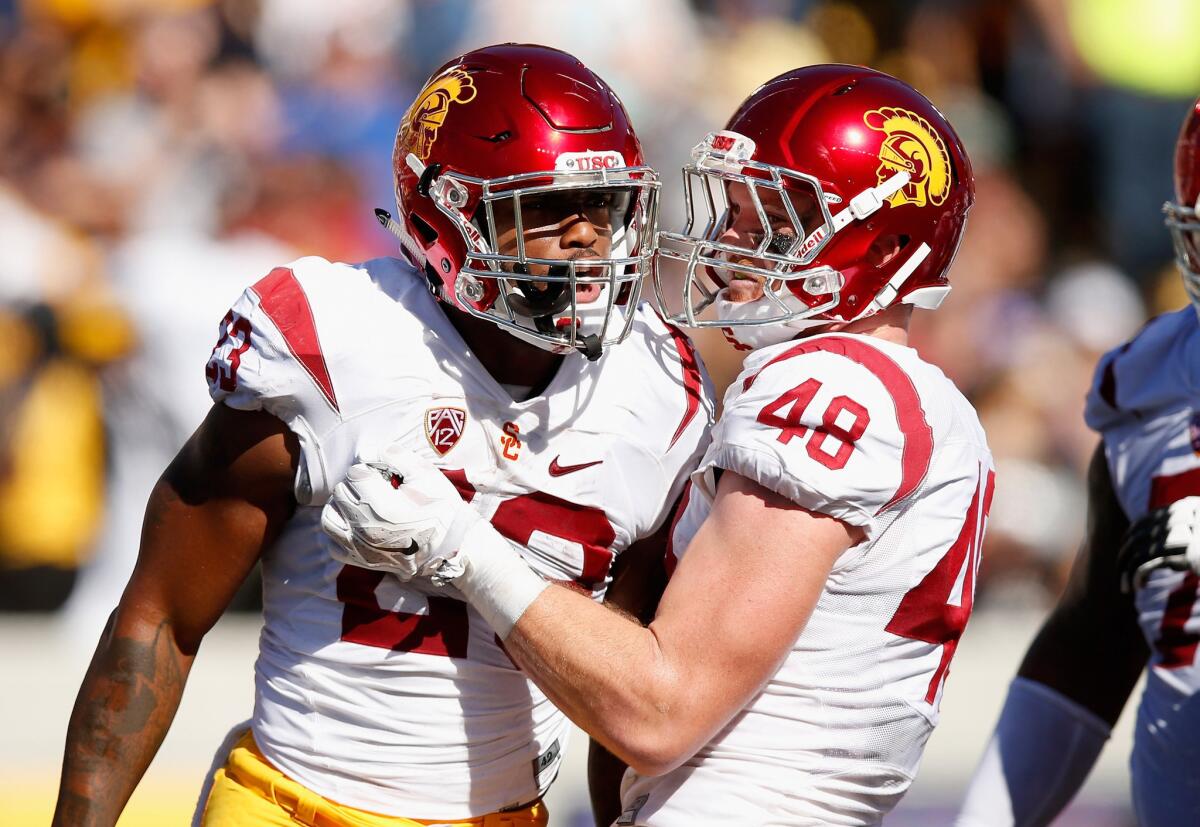 Running back Tre Madden (23) is congratulated by USC teammate Taylor McNamara (48) after Madden scored a touchdown against California.