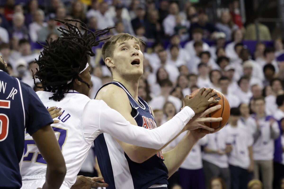 Arizona forward Azuolas Tubelis, right, looks to the basket with Washington guard Keyon Menifield defending during the first half of an NCAA college basketball game, Saturday, Jan. 28, 2023, in Seattle. (AP Photo/John Froschauer)