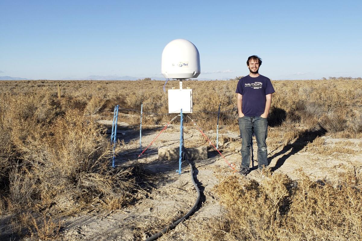 Caltech radio astronomer Christopher Bochenek stands with a STARE2 station he developed.