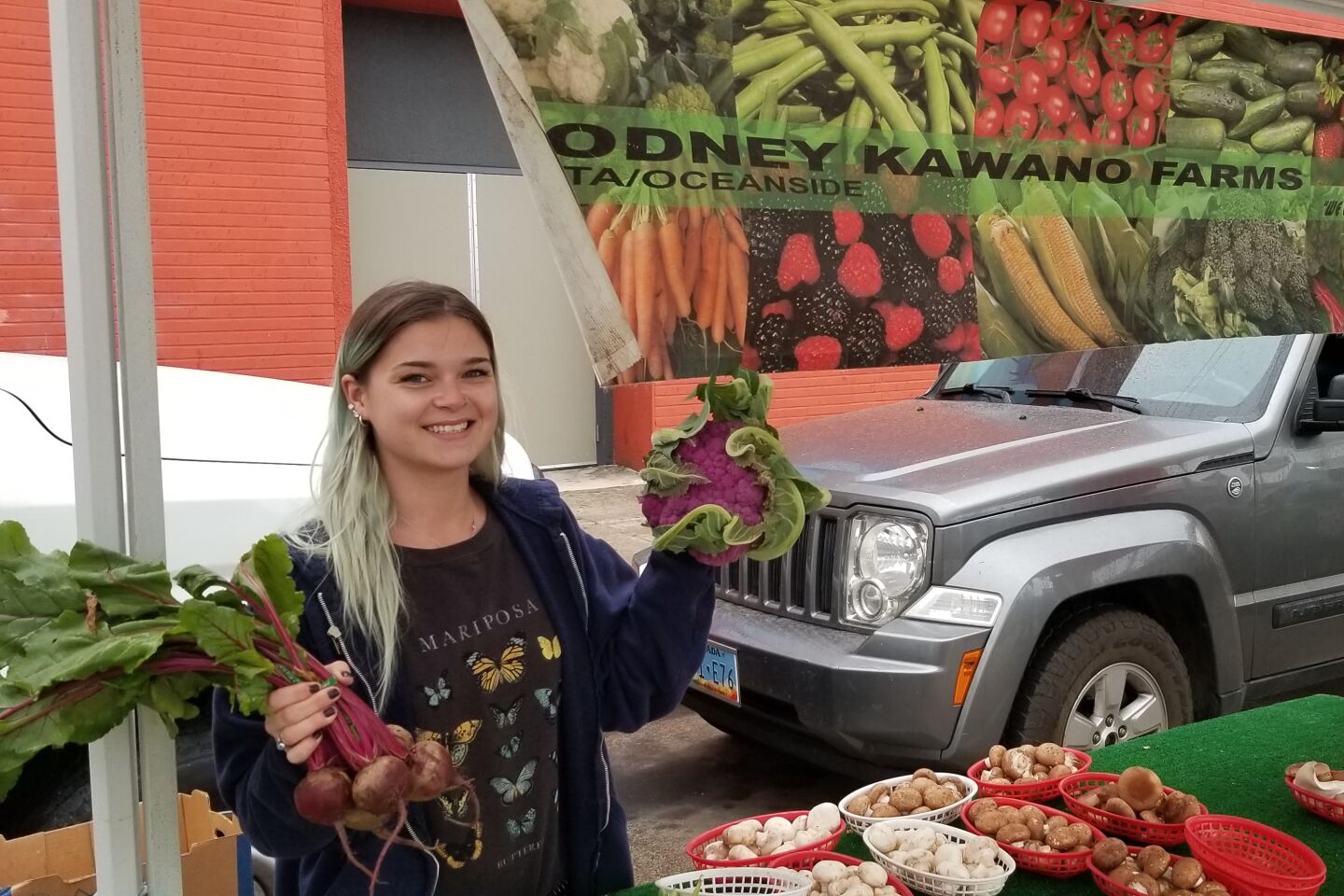 Courtlynn S. poses with produce from Rodney Kawano Farm.