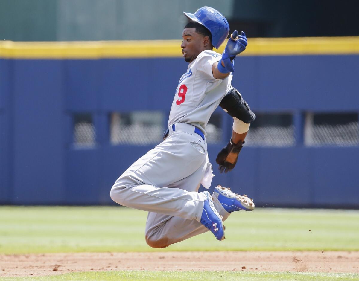 Dodgers second baseman Dee Gordon gets airborne as he begins to slide safely into second base on a steal attempt against the Braves in the third inning Thursday afternoon in Atlanta.