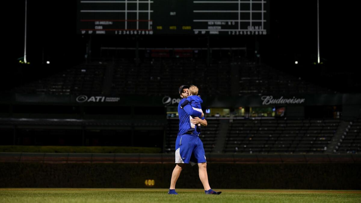 Clayton Kershaw carries his son, Charley, on the field at Wrigley Field after the Dodgers routed the Cubs in Game 5 of the National League Championship Series in October 2017.