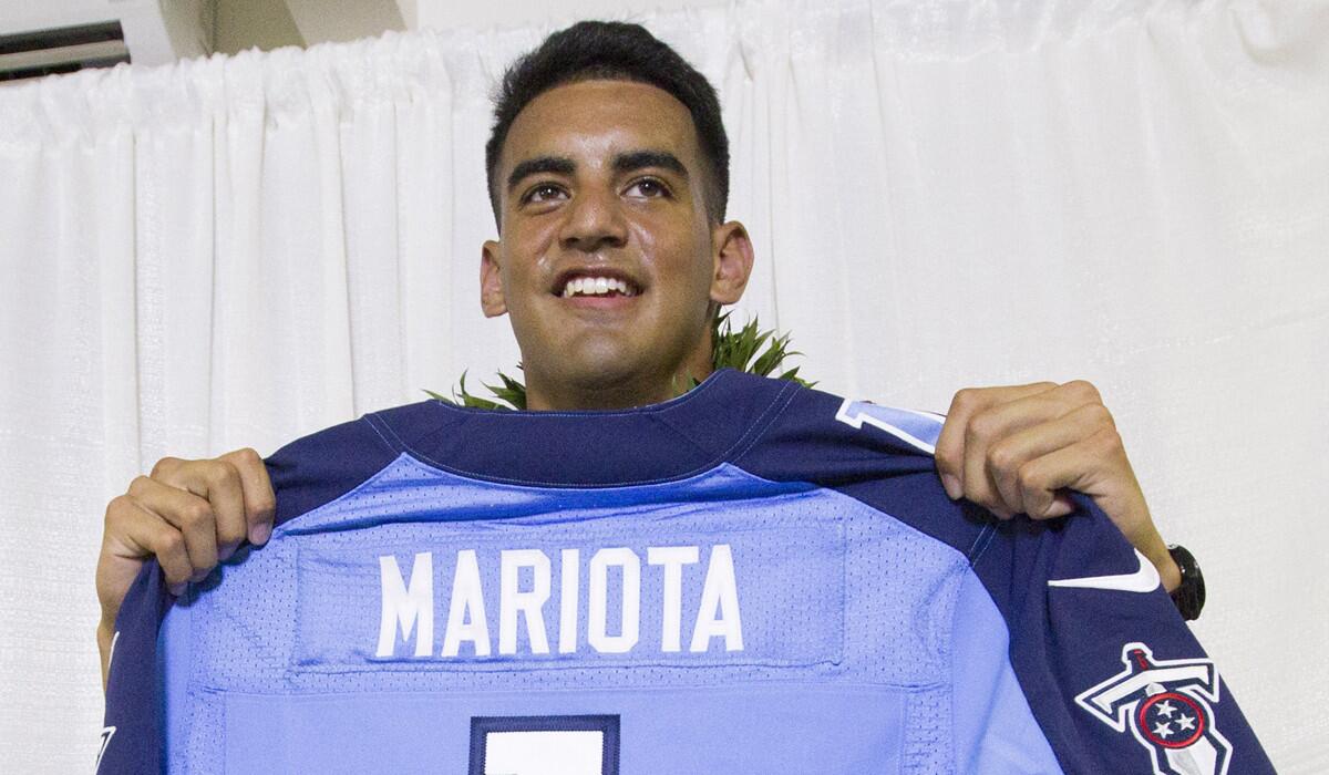 Former Oregon quarterback Marcus Mariota holds up his Tennessee Titans jersey after being picked second overall in the NFL draft on Thursday night.