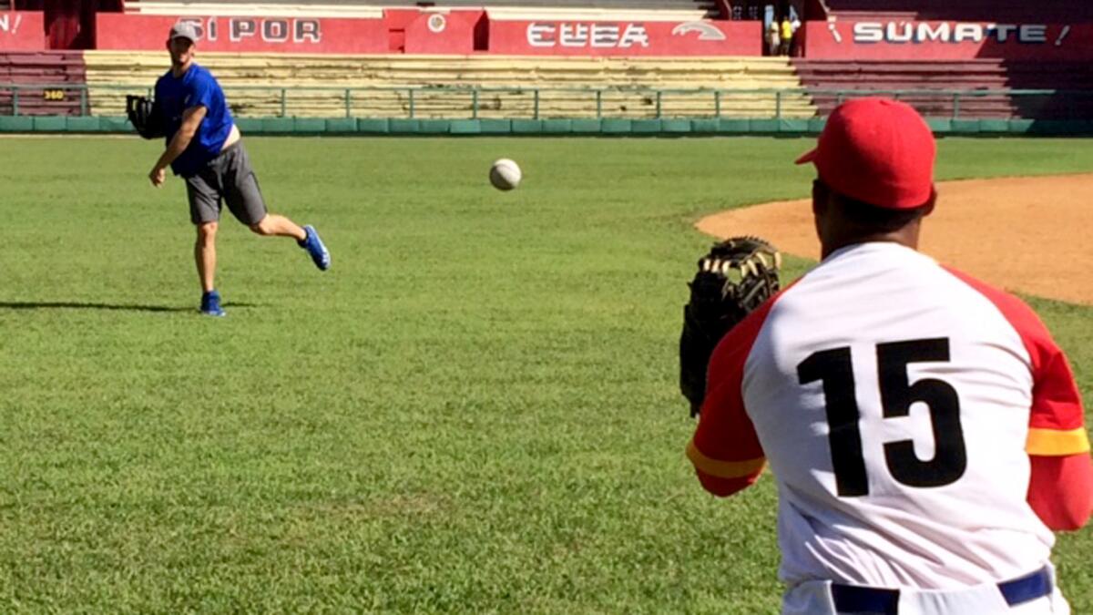 Dodgers pitcher Clayton Kershaw does a long-toss drill with Cuban catcher Roberto Loredo during a workout in Cuba on Thursday.