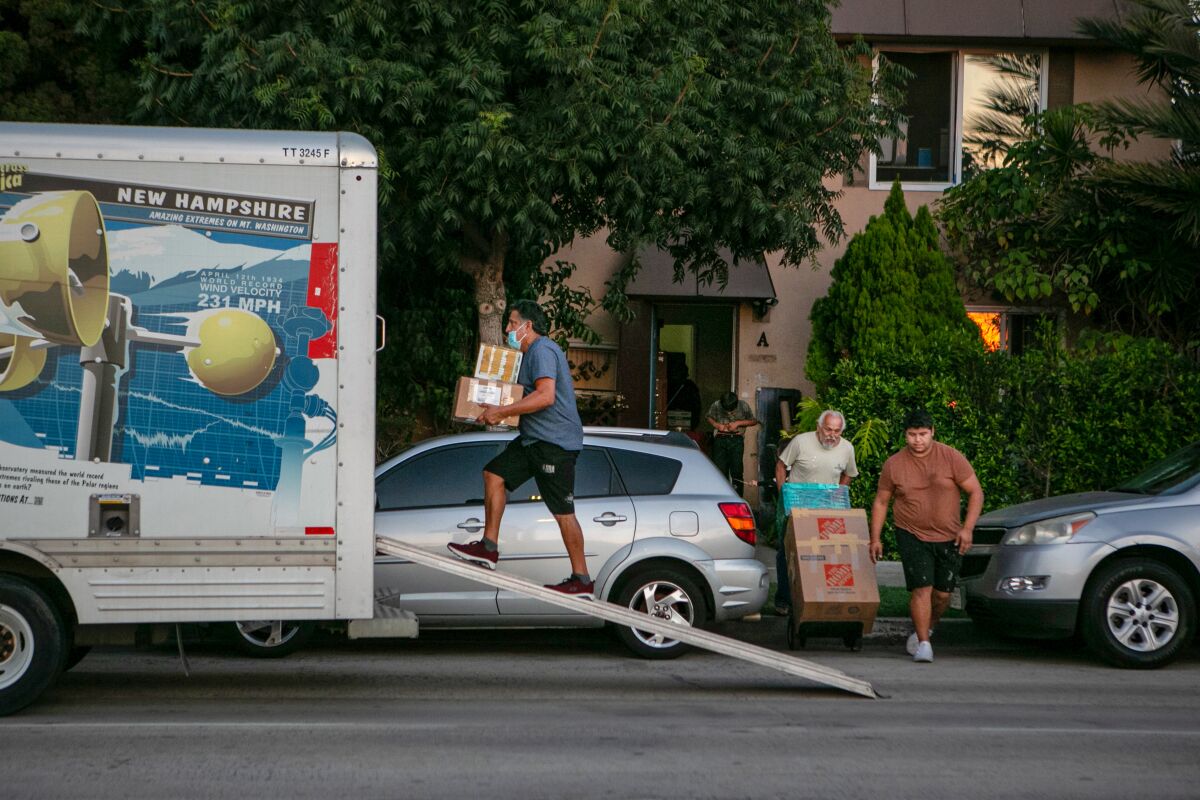 Family members load a U-Haul truck as they move from Los Angeles.