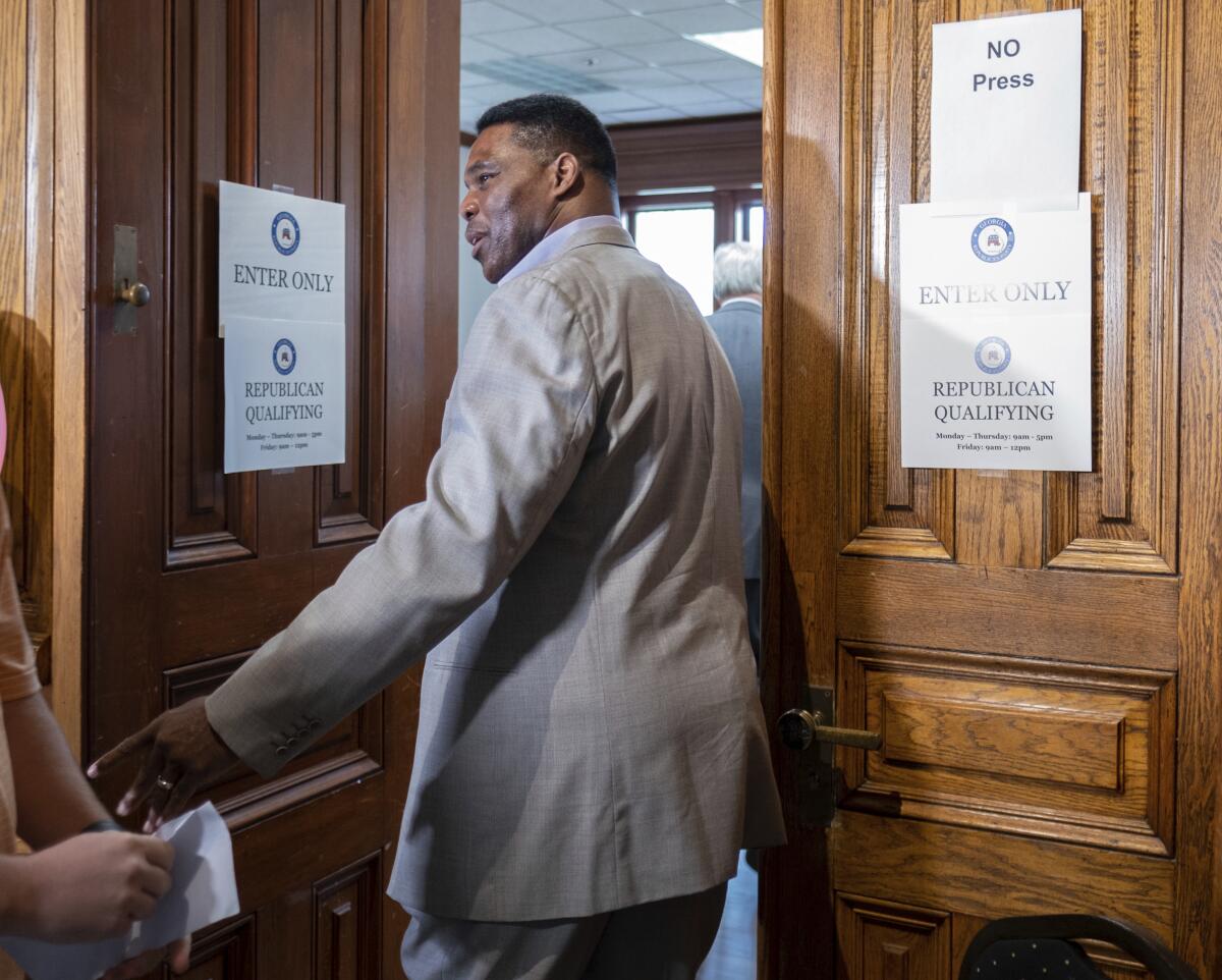 Herschel Walker enters a room to qualify to run for U.S. Senate at the Georgia State Capitol in Atlanta on Monday, March 7, 2022. (Ben Gray/Atlanta Journal-Constitution via AP)