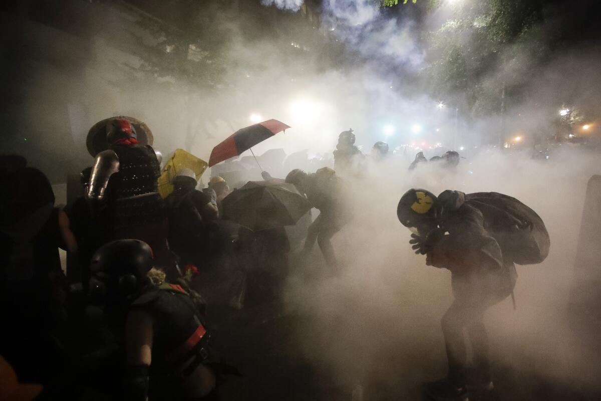 Federal officers launch tear gas at a group of demonstrators in Portland, Ore., on Sunday.