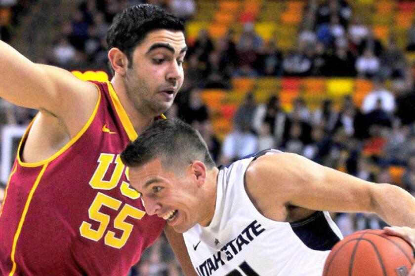 Utah State's Spencer Butterfield, right, drives around USC center Omar Oraby during the first half of the Trojans' 78-65 season-opening loss Friday.
