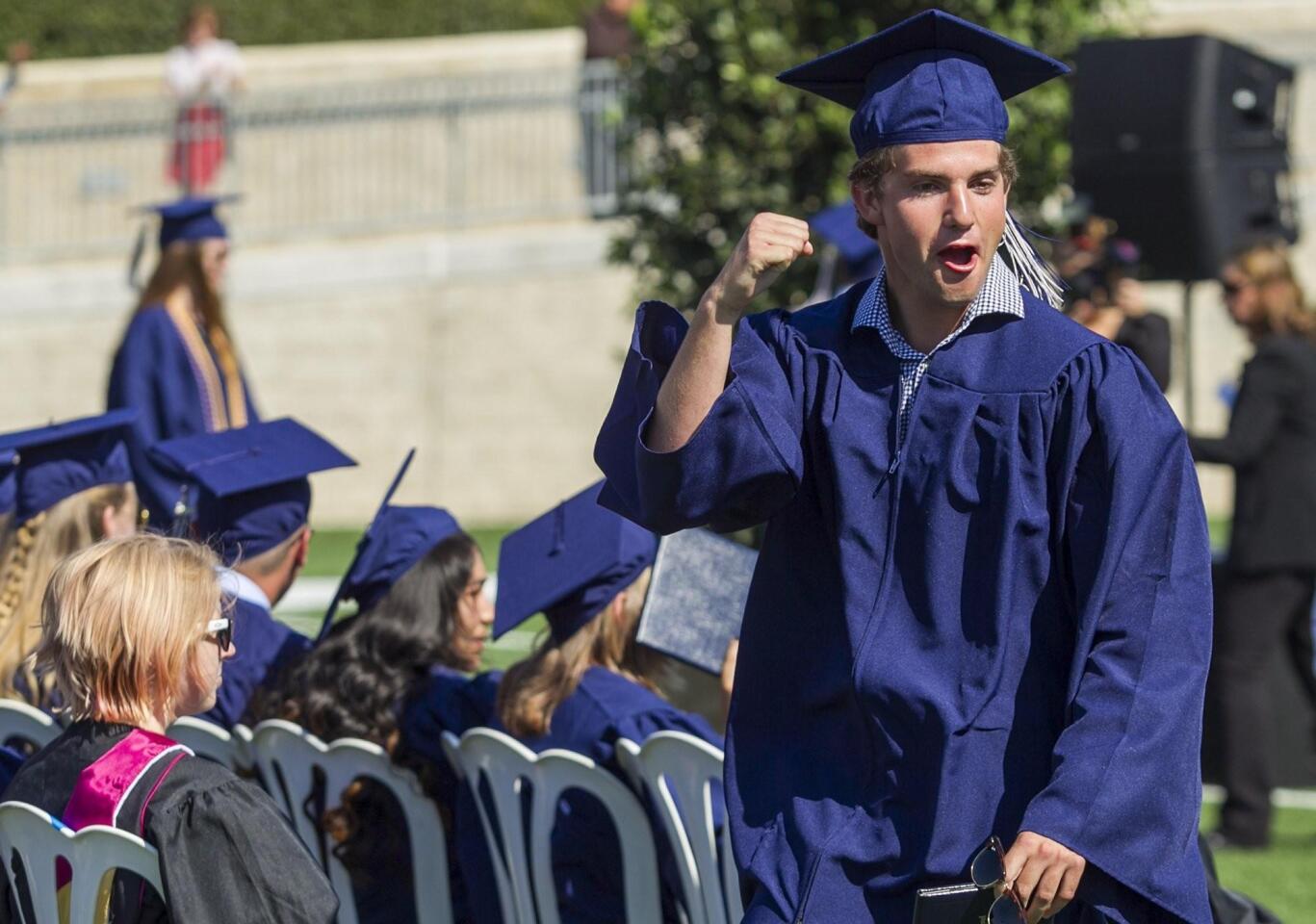 George Paspalof gestures to a fellow graduate during the 2016 commencement ceremony for Newport Harbor High School at Orange Coast College on Thursday.